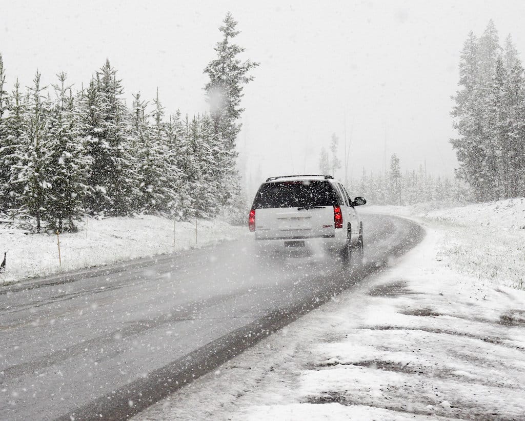SUV driving on snowy forest road
